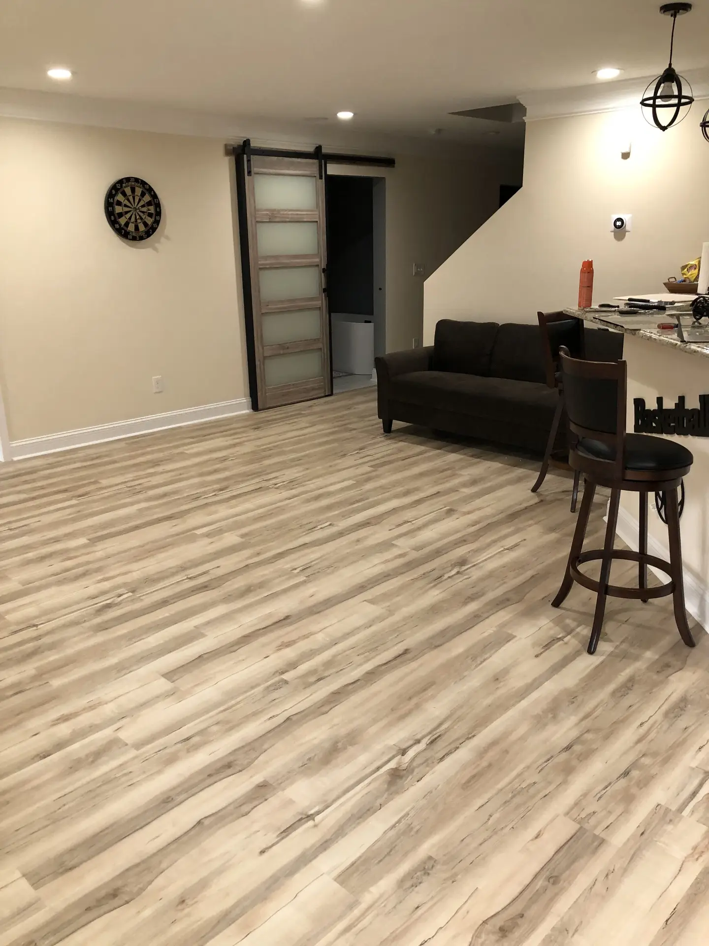 Finished basement living room space build out with new flooring and lighting