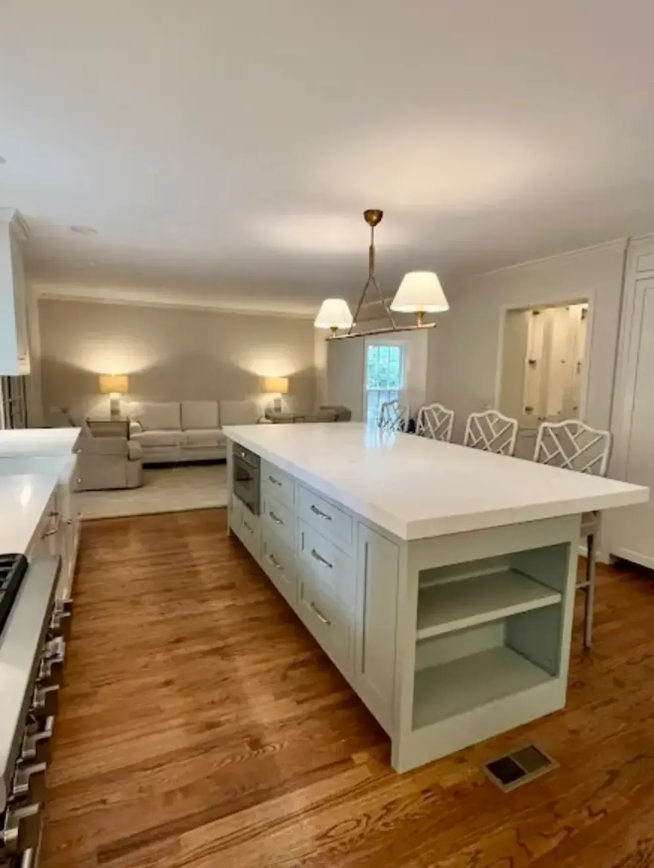 Completed kitchen renovation with custom island, updated cabinetry, lighting, and hardwood floors