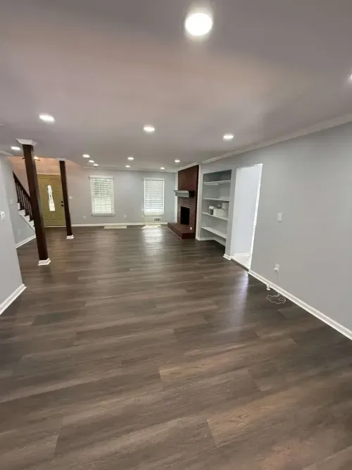 Completed fire damage restoration living room with new flooring, drywall, lighting, and fresh paint